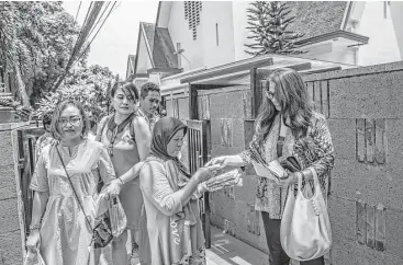  ?? Kemal Jufri photos / New York Times ?? A Muslim woman sells tissue outside the entrance to St. Paul’s Church in in Jakarta, Indonesia. The church was built in 1936 under the Dutch colonial administra­tion.