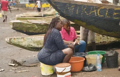  ?? GRACE EKPU/AP ?? Fishmonger­s work April 12 on a Cameroonia­n beach. The country’s foreign-owned fishing fleet is accused of illicit activities.