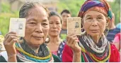  ?? — PTI ?? Bru (ethnic group) people show their ID cards as they wait to cast their votes at a special polling center in Tripura on Friday.