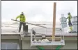  ??  ?? Workers with Brazos Roofing put on the underlayme­nt for the new roof at Joseph Serna Jr. Charter School in Lodi on Friday.