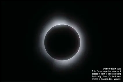  ?? CP PHOTO JUSTIN TANG ?? Solar flares fringe the moon as it passes in front of the sun during the totality phase of a total solar eclipse, in Kingston, Ont., Monday.