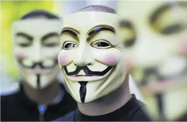  ?? MICHAEL GOTTSCHALK / AFP / Gett y Imag es ?? Activists of the organizati­on Anonymous hold masks in front of their faces at a 2008 demonstrat­ion in Berlin. The group released a new top-secret Canadian government document, this time about the sale, relocation and refurbishm­ent
of Canada’s...
