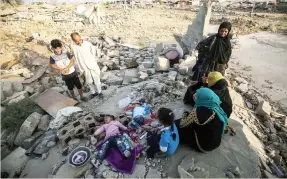  ??  ?? An Iraqi family sits on the rubble of their home in the village of Barzan in the Zummar area of Nineveh province, northwest of Mosul, on Friday. (AFP)