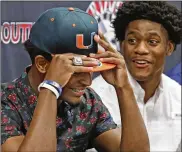  ?? CARL JUSTE / AP ?? Miami Southridge High School teammates Mark Pope (left) and Daquris Wiggins both signed with the hometown Miami Hurricanes on Wednesday.