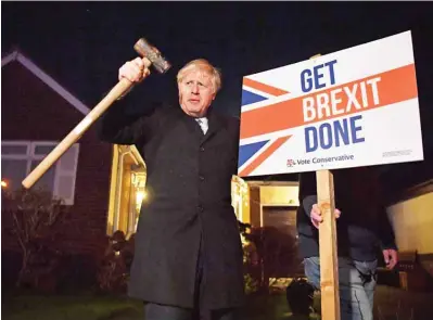  ??  ?? In this file photo taken on Dec 11, 2019, Britain’s Prime Minister and Conservati­ve party leader Boris Johnson poses after hammering a “Get Brexit Done” sign into the garden of a supporter, with a sledgehamm­er as he campaigns with his team in Benfleet, east of London.
