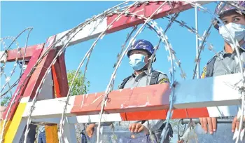  ?? — AFP photo ?? Police stand guard along a road in Naypyidaw, ahead of the reopening of the parliament on Feb 1 following the November 2020 elections which Suu Kyi’s ruling NLD won in a landslide.