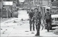  ?? ROMEO RANOCO / REUTERS ?? Policemen stand guard along the main road of Marawi City as government forces continue their assault against militants on Thursday.