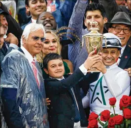  ?? ANDY LYONS / GETTY IMAGES ?? Trainer Bob Baffert (left) celebrates his fifth Kentucky Derby victory with son Bode and jockey Mike Smith, who now has two Derby wins of his own.
