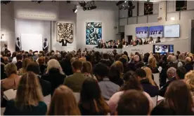  ?? ?? Auctioneer Oliver Barker leads the sale of the Macklowe Collection, alongside Andy Warhol's Sixteen Jackies (centre) at Sotheby's in New York. Photograph: Yuki Iwamura/AFP/ Getty Images