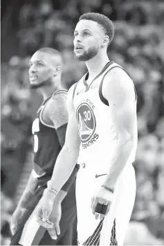  ?? - AFP photo ?? Damian Lillard #0 of the Portland Trail Blazers and Stephen Curry #30 of the Golden State Warriors look on during the second half in game one of the NBA Western Conference Finals at ORACLE Arena on May 14, 2019 in Oakland, California.