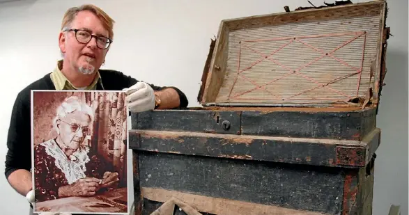  ?? COLIN WILLIAMS/FAIRFAX NZ ?? Upper Hutt City Library historian Reid Perkins with the late-1800s travel chest and a photo of Mary McCurdy, a Revelle Jackson image taken on her 100th birthday in 1965. Mary was the wife of Angus, Upper Hutt’s first mayor.