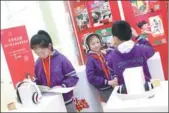  ?? PROVIDED TO CHINA DAILY ?? Primary school students comb through paper books or listen to audiobooks at a Beijing event to promote reading.