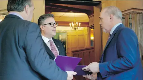  ?? CHAD HIPOLITO/THE CANADIAN PRESS ?? B.C. Green party Leader Andrew Weaver, left, and NDP Leader John Horgan arrive at Government House Wednesday to drop off a document to Director of the House Jeremy Brownridge, centre. Signed by 44 MLAs, it shows there’s a deal between the two parties.