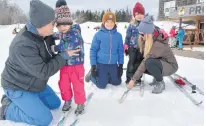  ?? ERIC MCCARTHY/JOURNAL PIONEER ?? Thatcher MacKay, center, watches as his parents, Andrew and Robyn, assists his sisters, Elliott, second left, and Everleigh with their skis. Fears over the coronaviru­s led to the Cape Traverse family cancelling their March Break excursion to Halifax in favour of an outing closer to home.