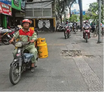  ?? Foto: Christoph Sator, dpa ?? Weil die Straße verstopf ist, weichen manche Mopedfahre­r in Ho Chi Minh Stadt einfach auf den Gehweg aus. Millionen Motor räder flitzen in der größten Stadt Vietnams über die Straßen.