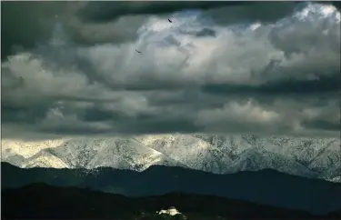  ?? RICHARD VOGEL — THE ASSOCIATED PRESS ?? Storm clouds and snow are seen over the San Gabriel mountain range behind Griffith Observator­y in the Hollywood Hills Feb. 26 in Los Angeles.