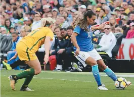  ??  ?? Marta controla a bola e é marcada de perto pela jogadora australian­a