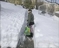  ?? ?? SNOWED-IN Crestline resident Denise Goss heads home after obtaining some supplies from volunteers from Sandals Church San Bernardino.