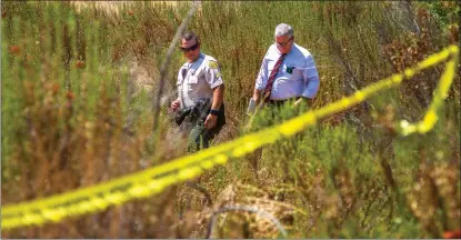  ?? Austin Dave/The Signal ?? Los Angeles County sheriff’s Deputy Joel Anzures leads Detective Steven Lankford to a body off Pico Canyon Road on Saturday.