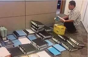  ??  ?? An Inland Revenue Board officer at the office of one of Tun Dr Mahathir Mohamad’s sons in Kuala Lumpur yesterday.