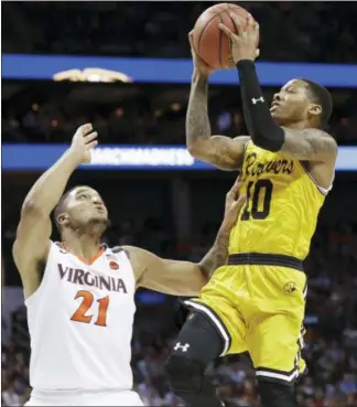  ?? GERRY BROOME - AP ?? UMBC’s Jairus Lyles (10) shoots over Virginia’s Isaiah Wilkins (21) during the second half of a first-round game in the NCAA men’s college basketball tournament in Charlotte, N.C., Friday.