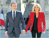  ??  ?? Corridors of power: Brigitte Macron strolls through the Élysée Palace courtyard hand-in-hand with her husband, Emmanuel, the French President