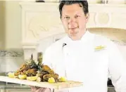  ?? Tina Case ?? Tyler Florence displays fried chicken complete with fried herbs, garlic and lemon wedges.