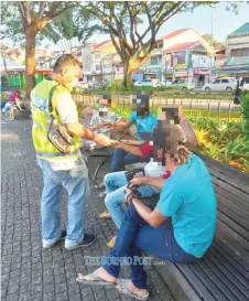  ??  ?? A policeman collects the personal identifica­tion documents of SOP violators, who were subsequent­ly issued compounds, during an inspection carried out last weekend at Kuching Waterfront.