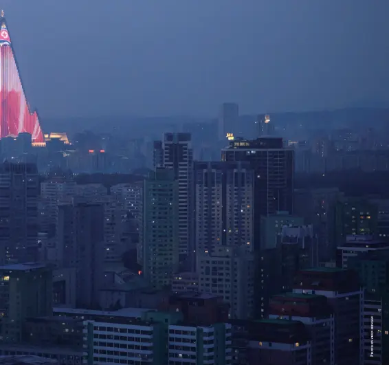  ??  ?? A huge LED display of the North Korean flag on the side of the iconic Ryugyong Hotel, which has yet to open 30 years after constructi­on started , Pyongyang, North Korea