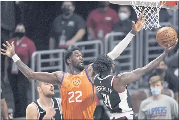  ?? MARK J. TERRILL — THE ASSOCIATED PRESS ?? Clippers guard Patrick Beverley, right, shoots as Suns center Deandre Ayton defends during the Western finals.