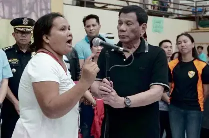  ?? MALACAÑANG­PHOTO ?? CONFRONTAT­ION President Duterte holds the microphone stand as Shiela Eballe rants against quarrying during Mr. Duterte’s visit to Naga City to condole with relatives of those who died in a massive landslide there on Sept. 21.—