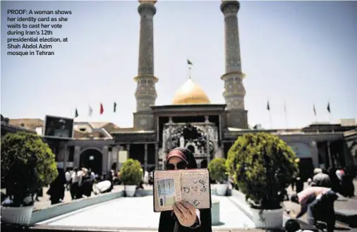  ??  ?? PROOF: A woman shows her identity card as she waits to cast her vote during Iran’s 12th presidenti­al election, at Shah Abdol Azim mosque in Tehran