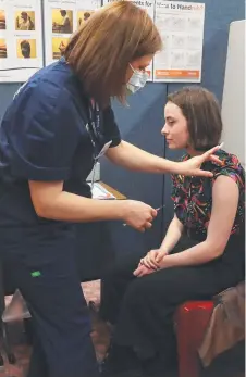  ??  ?? Elizabeth College student Holly Horne, 16, gets her first Pfizer vaccinatio­n from nurse by Anne-Maree Kroon.