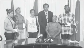  ??  ?? Minister Khemraj Ramjattan (third from right) standing with the relatives of the five of the piracy victims, namely Glenroy Jones, Sunil Ramotar known as ‘Poddock’, Sherwin Lovell, Vicky Persaud and Deonarine following the handing over of the cheques yesterday. (Terrence Thompson photo)