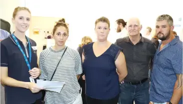  ??  ?? EPA senior engagement officer Stacey Clark (left) discusses the saleyards proposal with Longwarry residents (from left) Zoe Sloan, Melissa McCoy, John Maes and Ben McCoy.