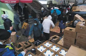  ?? James Estrin / New York Times ?? Food is distribute­d outside a Manhattan church this month. The need for assistance is growing.