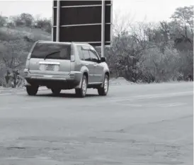  ??  ?? A motorists avoids baboons playing on the road causing a traffic hazard in Hwange town on Friday. Picture by Dennis Mudzamiri