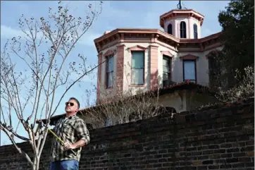  ?? Staff photo by Curt Youngblood ?? Jackson Garner trims crepe myrtles in front the Ace of Clubs House on Saturday morning. Several community members gathered at the house to tidy up the grounds.