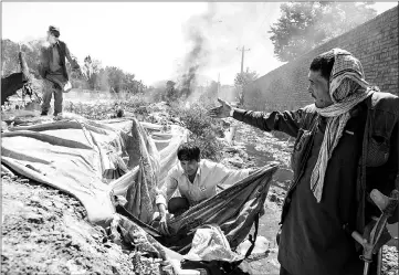  ??  ?? While staff from the rehab centre search for women in the dry bed of the Kabul River near the capital’s notorious addict colony under the Pule Sukhta bridge, plaincloth­es police destroy makeshift shelters at the site.