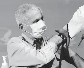  ?? PATRICK SEMANSKY/AP ?? Dr. Anthony Fauci prepares to receive his first dose of the COVID-19 vaccine Dec. 22 at the National Institutes of Health in Bethesda, Maryland. After a slow start, almost 4 million shots have been administer­ed nationwide.