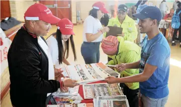  ?? PICTURE: TRACEY ADAMS/AFRICAN NEWS AGENCY (ANA) ?? ENLIGHTENI­NG: Beacon Hill High School in Mitchells Plain had a fund-raising drive to buy electronic equipment for its library. The Cape Argus was one of the sponsors. Here Ray de Wee, left, hands a newspaper and calendar to Hamish Daries, 18.