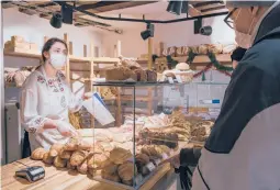  ?? ANDREA MANTOVANI/THE NEW YORK TIMES ?? Charlotte Noel sells baguettes Dec. 19 at a bakery in Paris. The price of a traditiona­l baguette is projected to rise up to 10 cents in 2022.