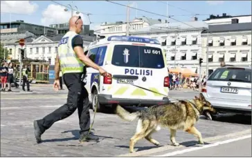  ?? HEIKKI SAUKKOMAA/AFP ?? A police officer patrols with his dog at a market in Helsinki, Finland, on Saturday.