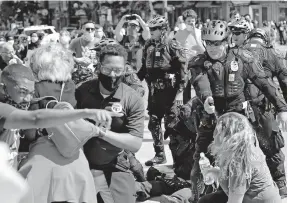  ?? [KYLE ROBERTSON/DISPATCH) ?? Columbus City Council President Shannon Hardin, pointing at left, was pepperspra­yed by police during a Downtown protest in May. With him are Franklin County Commission­er Kevin Boyce, center, and Congresswo­men Joyce Beatty, between them with back turned.