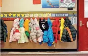  ?? [PHOTOS BY JIM BECKEL, THE OKLAHOMAN ARCHIVES] ?? New winter coats hang in a hallway outside kindergart­en classrooms at Shidler Elementary School in Oklahoma City in this photo from October 2016.