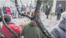  ?? ?? Olena Yermolenko, top, second from right, leads fellow resistance members in a rendition of the Ukrainian national anthem in the yard of her home in Kherson.