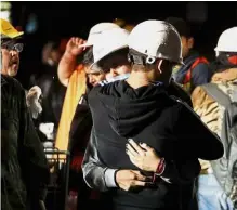  ??  ?? Human comfort: Workers consoling each other amid search and rescue efforts. — Reuters