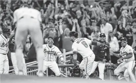  ?? Brynn Anderson / Associated Press ?? The Braves’ Eddie Rosario (8) celebrates after hitting a three-run homer in the fourth inning of Game 6 of the NL Championsh­ip Series.