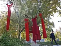  ?? Signal file photo ?? A COC student walks by red dresses displayed on campus in 2016. The “Red Dress Project,” which aims to shed light on domestic violence, will be traveling around Santa Clarita until Dec. 10.