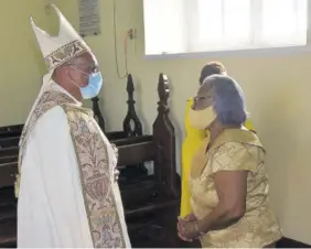  ?? (Photos: Karl Mclarty) ?? Bishop of Jamaica and the Cayman Islands Howard Gregory thanks Gloria Reid, wife of his predecesso­r Bishop Alfred Reid, after blessing the plaque mounted in the Cathedral of St Jago de la Vega yesterday to honour her husband’s ministry.